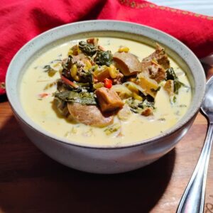 Mushroom chowder stew in a bowl with a spoon next to it and a red towel behind it.