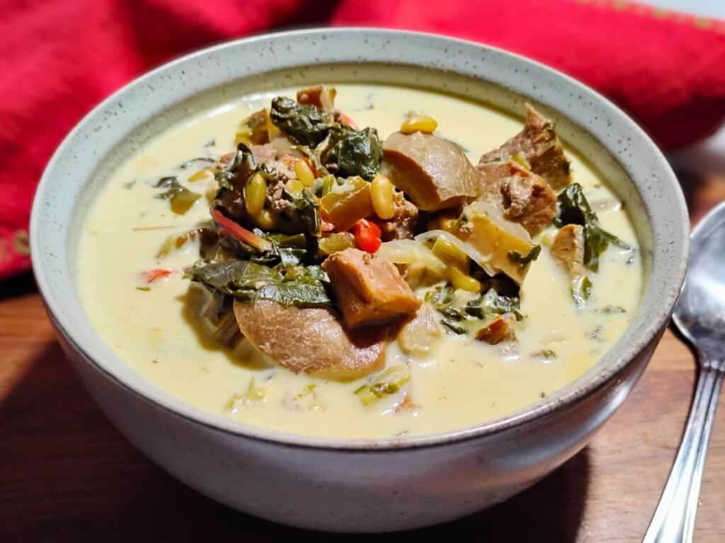 mushroom chowder soup in a bowl with a spoon beside it.