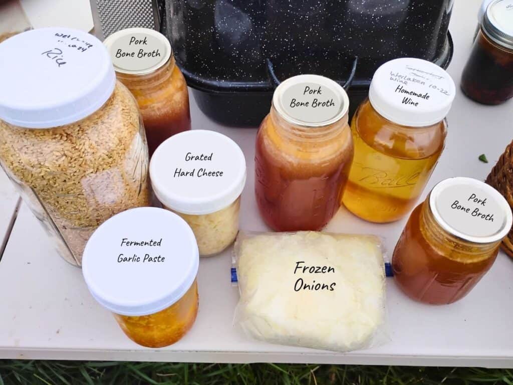 ingredients for mushroom risotto, bone broth, onions, rice, grated cheese, fermented garlic paste.