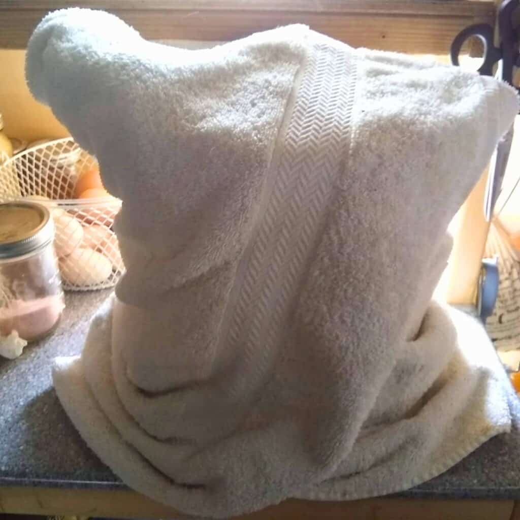 pot of milk is wrapped in a thick towel.