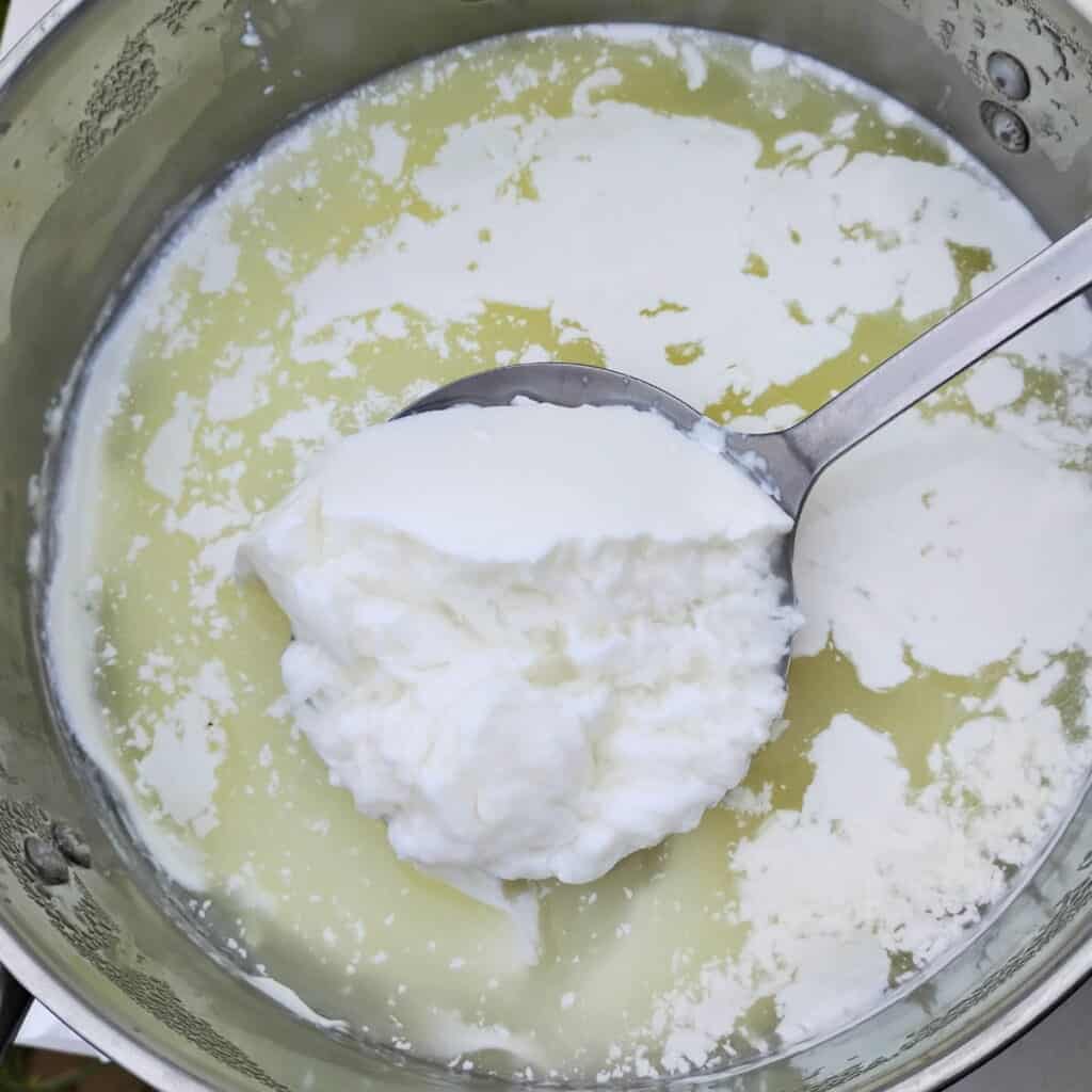 pot full of whey and curds for making quark cheese.