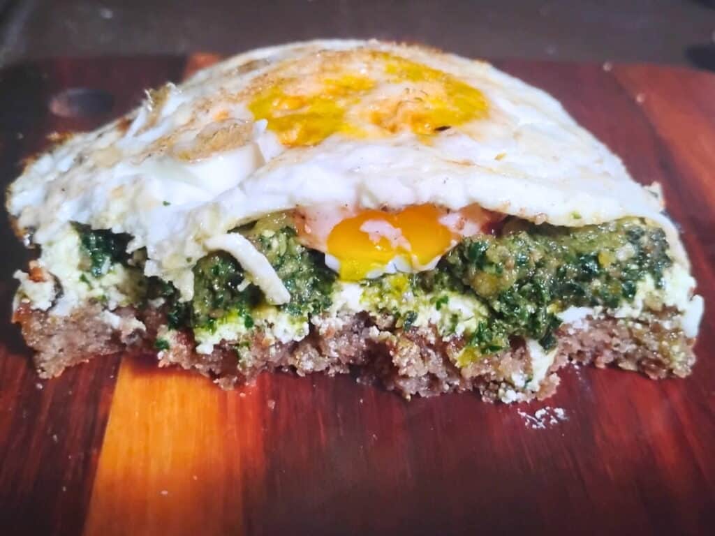 Sandwich topped with quark cheese, pesto and fried eggs.
