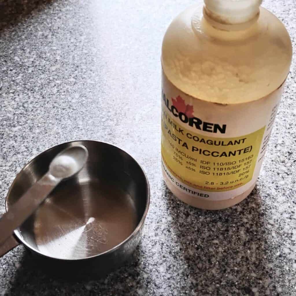 Walcoren rennet in a bottle and a spoon for dosing into a measuring cup