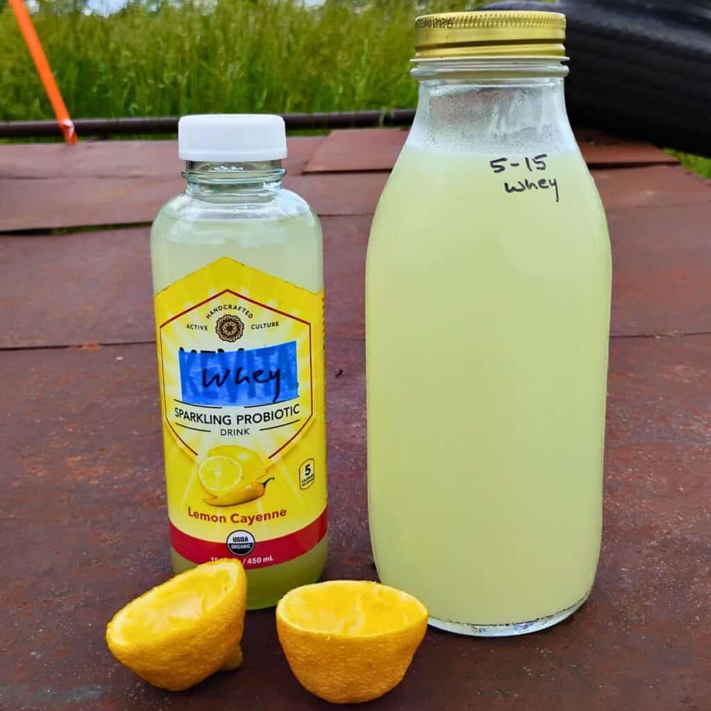 fermented lemonade soda made with whey as a starter. There is a bottle full of whey next to it and some squeezed out lemon peels in front.
