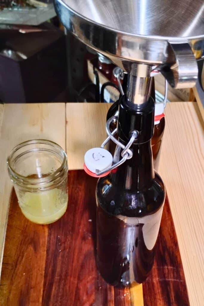 grolsch bottles with a funnel and a jar with lemon juice.