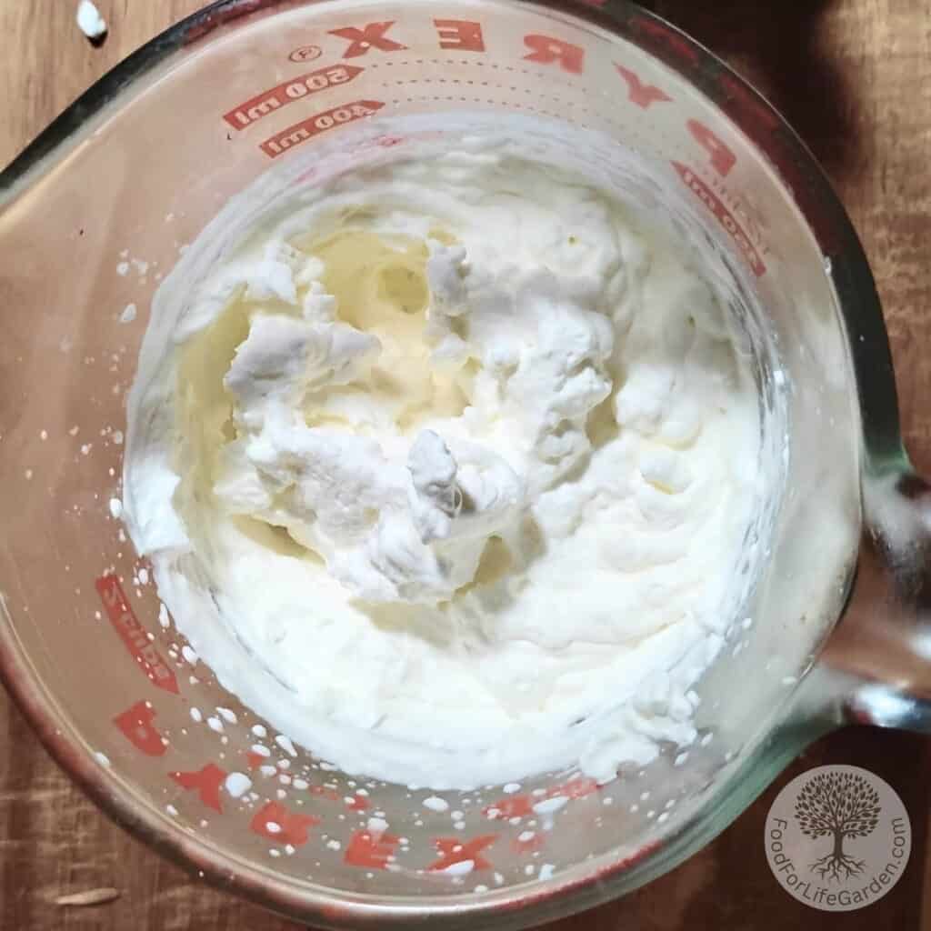 Whipped cream in a pint measuring pitcher.