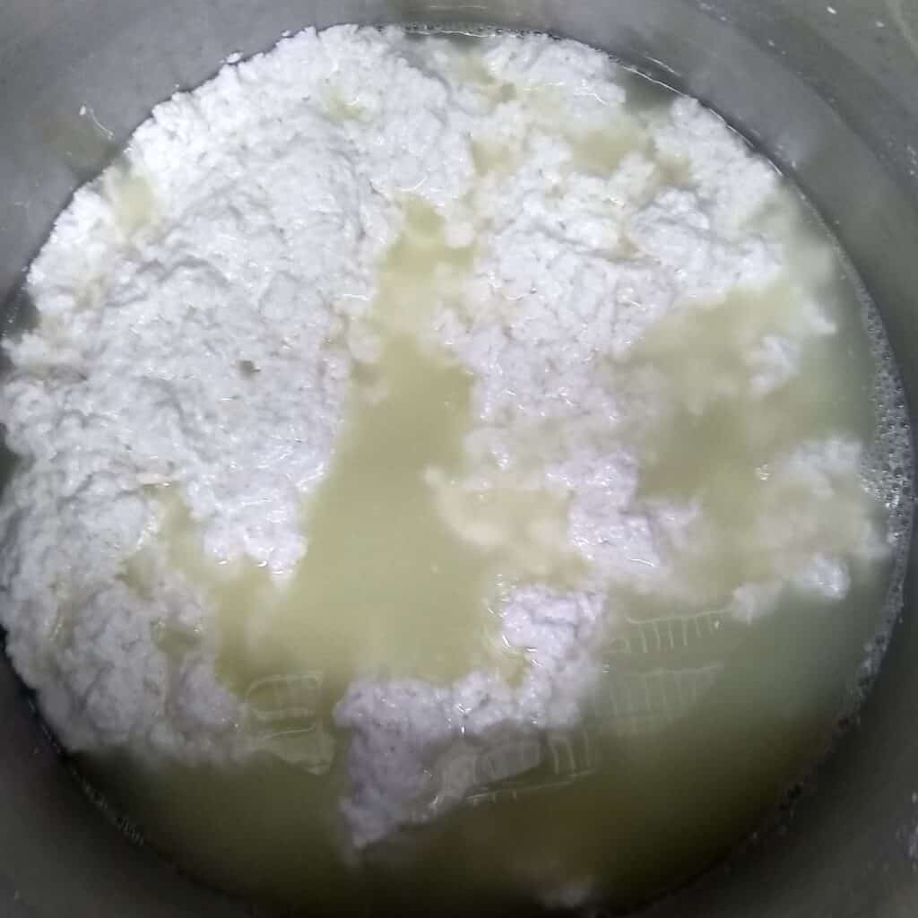 curds and whey in a pot for making queso fresco.