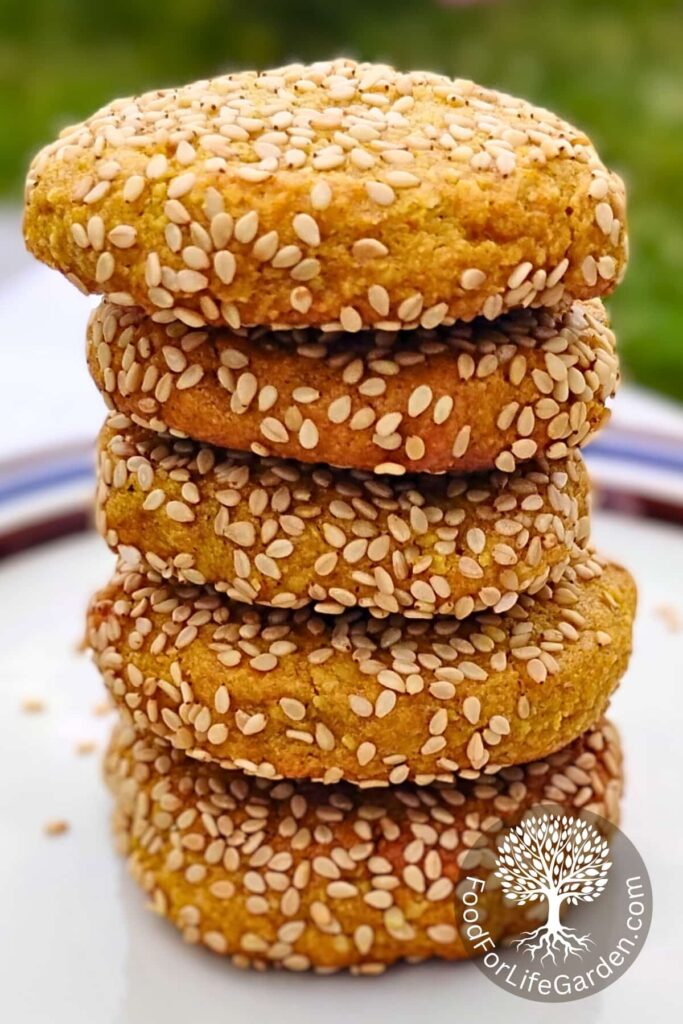 tall stack of honey and lemon tahini cookies, coated in sesame seeds on a plate.