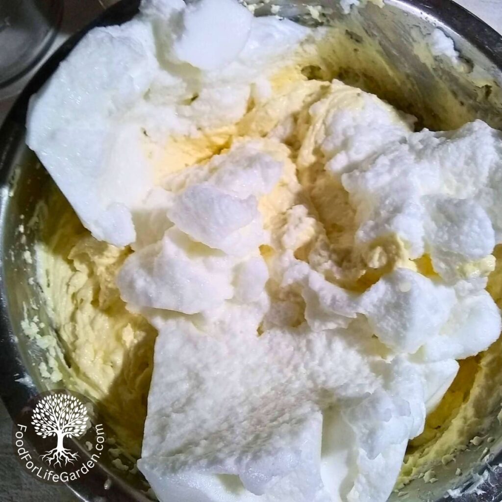 The stiff egg whites and whipped cream are added to the mixed cheese cake batter.