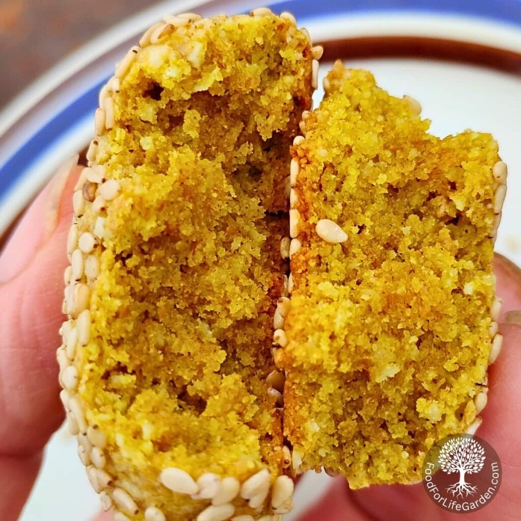 Lemon Tahini Cookie broken in half to reveal the strongly yellow interior, colored intensly from the honey and turmeric.