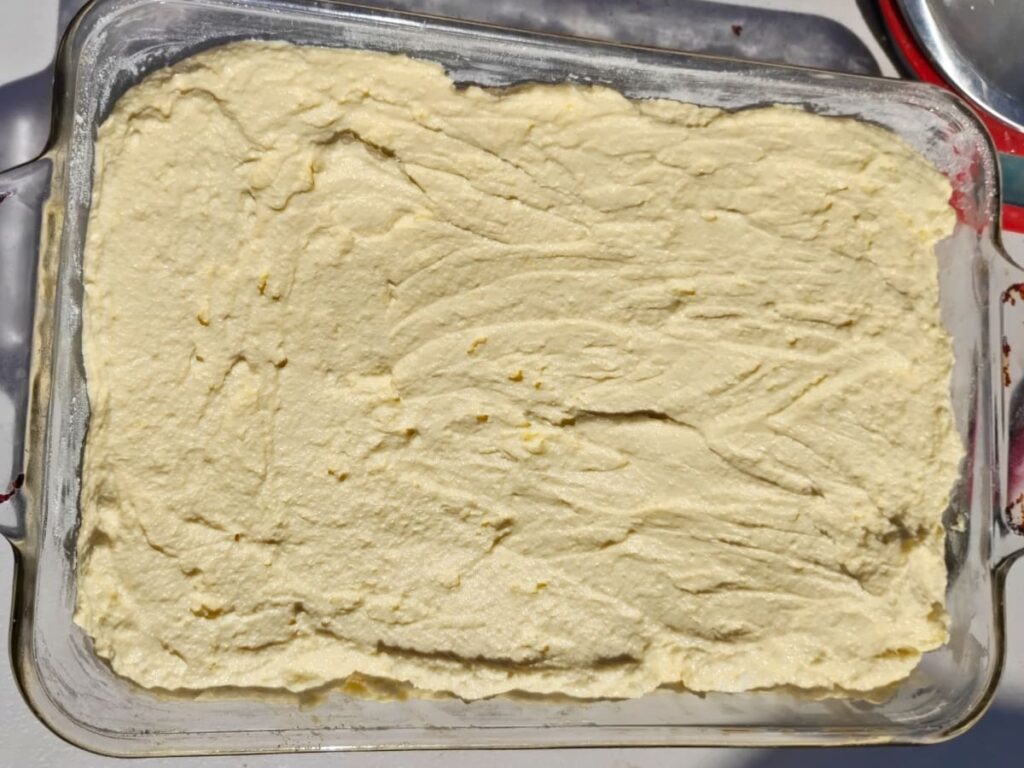 cheesecake filling is added to the baking dish and smoothed.