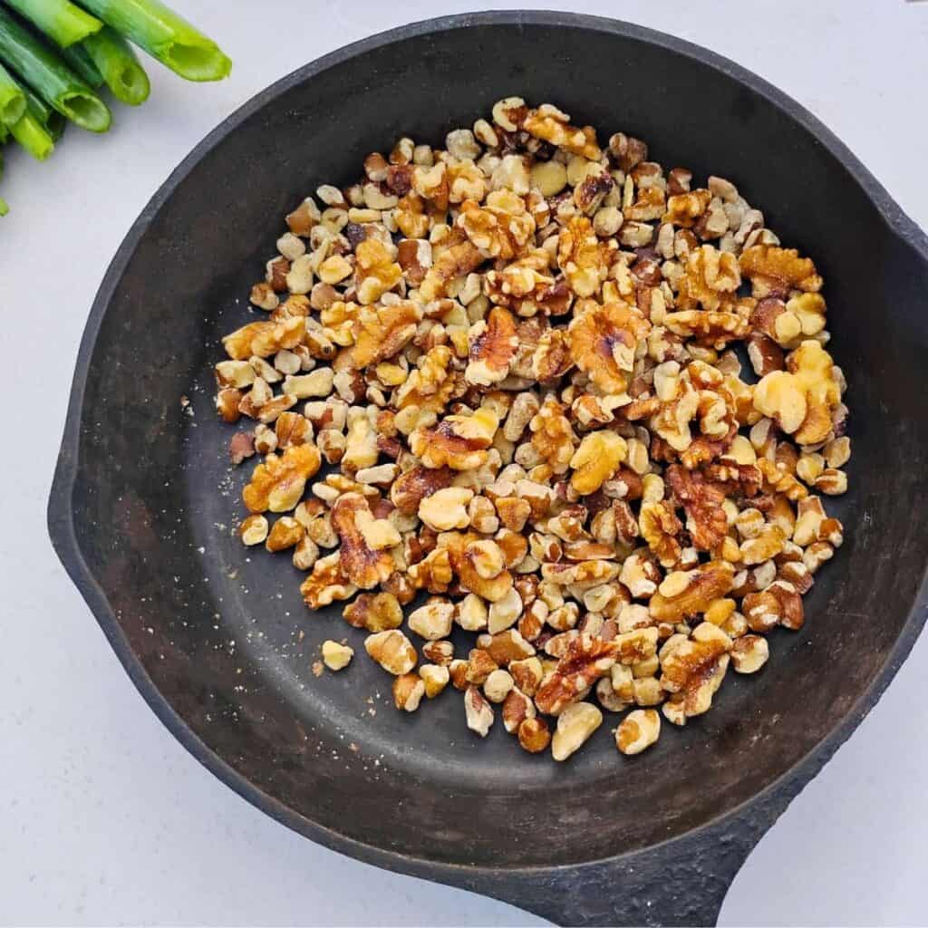 Walnuts getting toasted in a cast iron pan