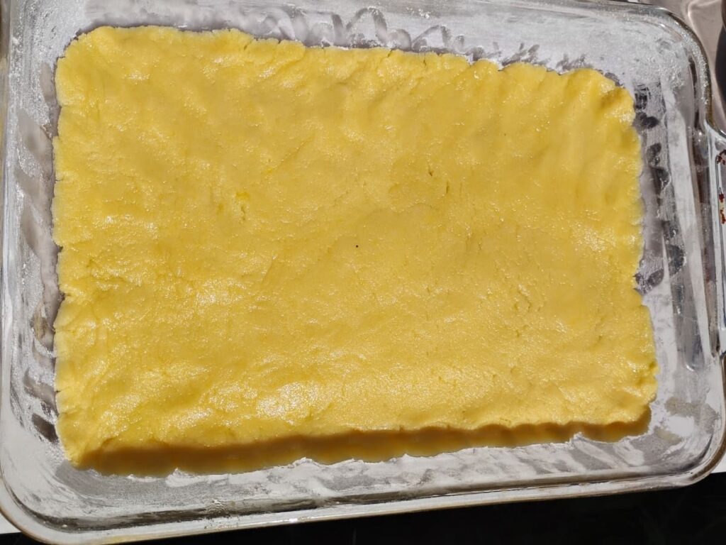 bottom of a baking dish is covered with cookie crust dough