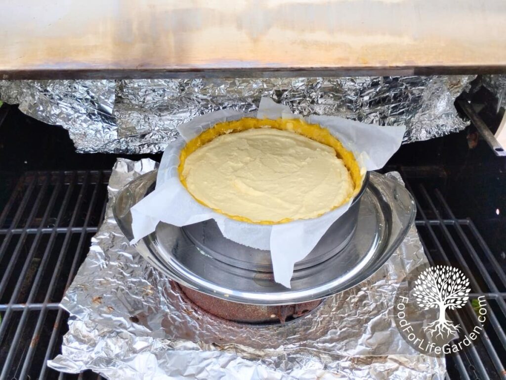 Cheesecake on a platter in the BBQ grill, ready to get baked.