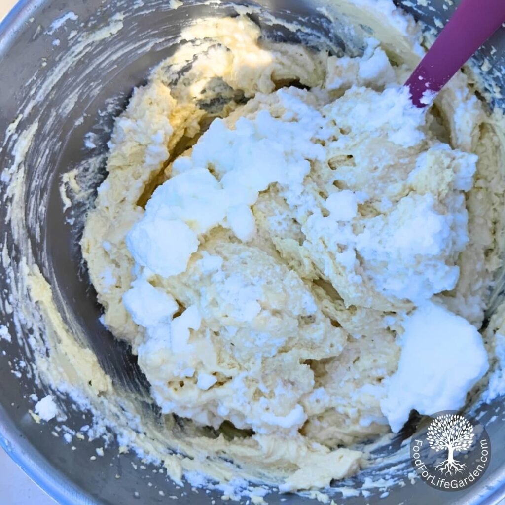 fluffy eggwhite is getting folded into the cheesecake batter.