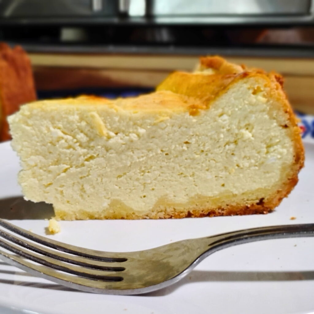 photo of a slice of German cheese cake or käsekuchen.on a plate with a fork