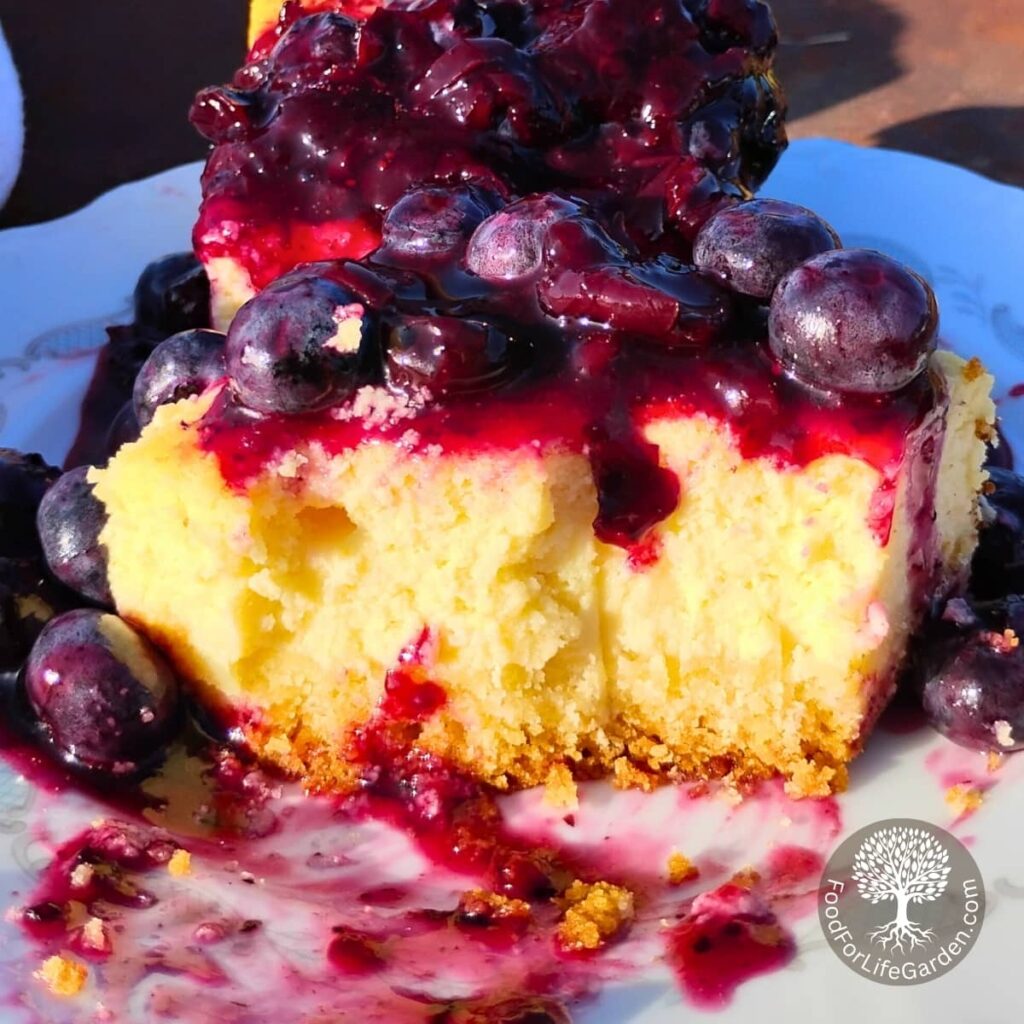a cheesecake piece covered with lemon blueberry sauce