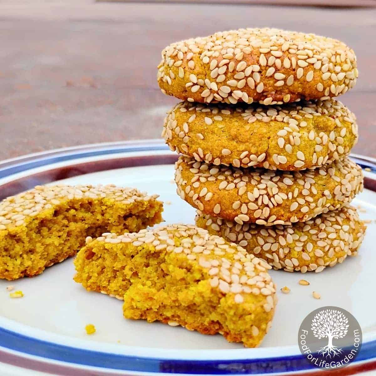 stack of spicy honey lemon tahini cookies with a broken cookie beside it on a plate.