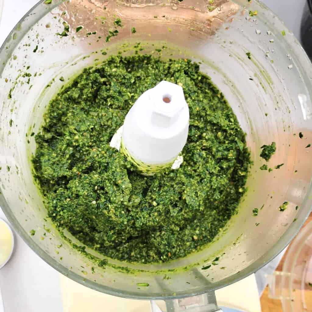 garlic scape pesto in a food processor bowl.