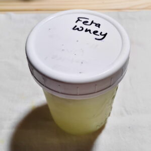 small jar full of feta whey for the next cheese making batch.