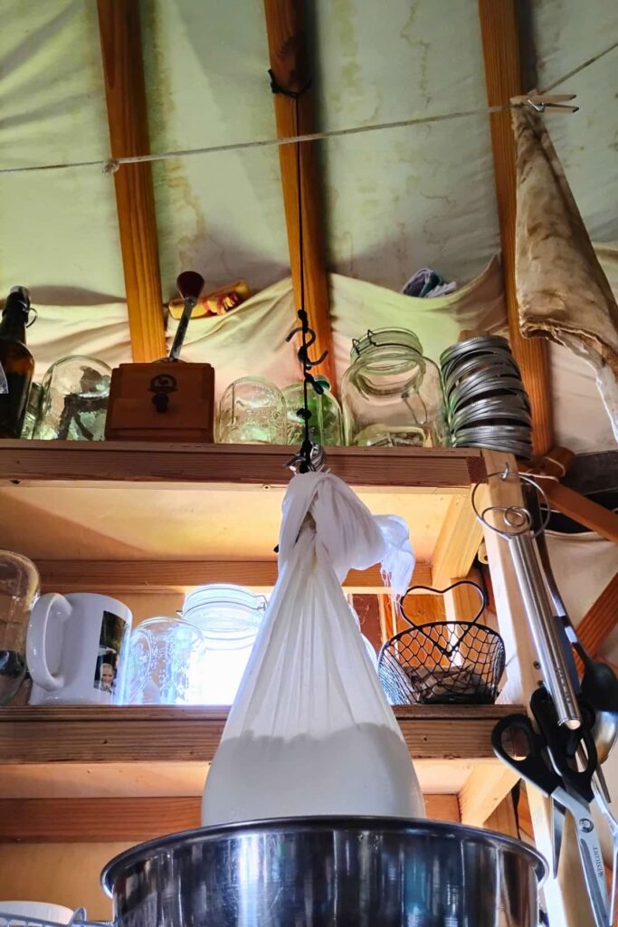 bag of cheese hanging from a hook on a string with loops that is tied to the rafter.