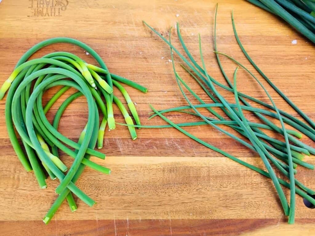 garlic scapes and cut off tips on a cutting board.