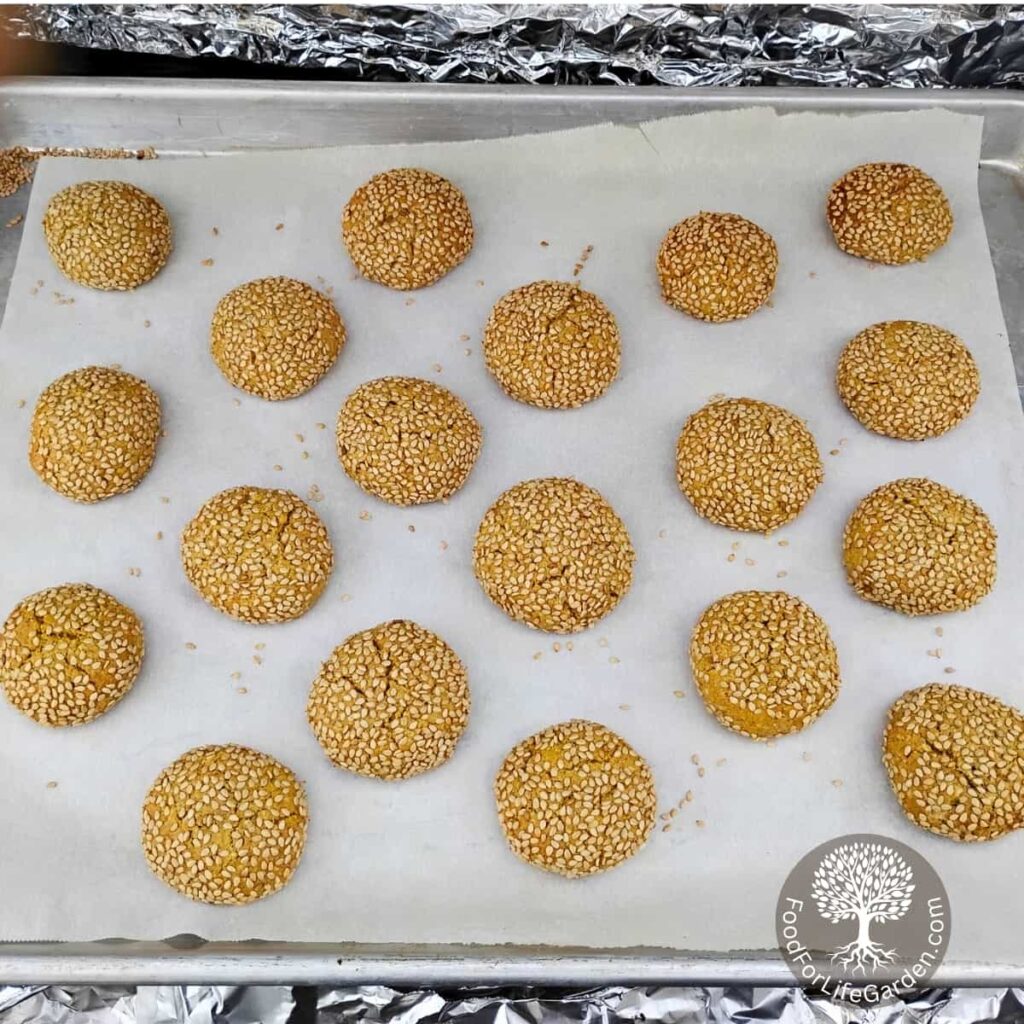 honey sesame tahini cookies on a baking sheet with parchment, fresh from the oven.