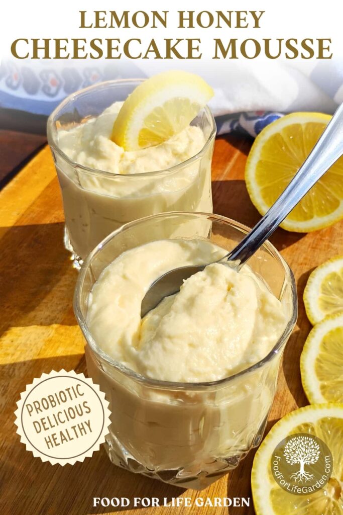 photo of a couple of serving glasses filled with lemon cheesecake mousse on a cutting board with lemons scattered aroud and a towel in the background. text overlay reads lemon honey cheesecake mousse. probiotic, delicious, healthy. food for life garden. 