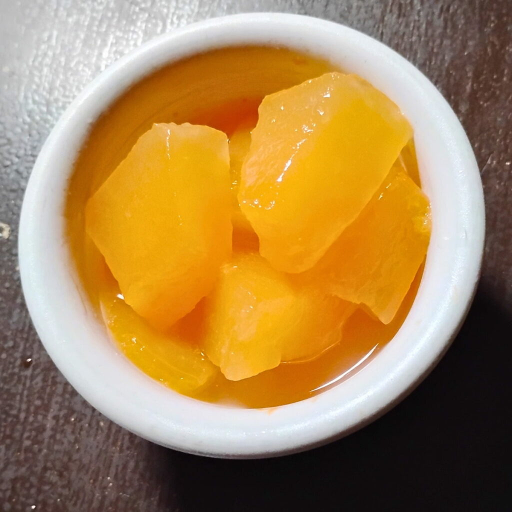 A bowl with a serving of fully fermented, 8 month old fermented cantaloupe pieces.