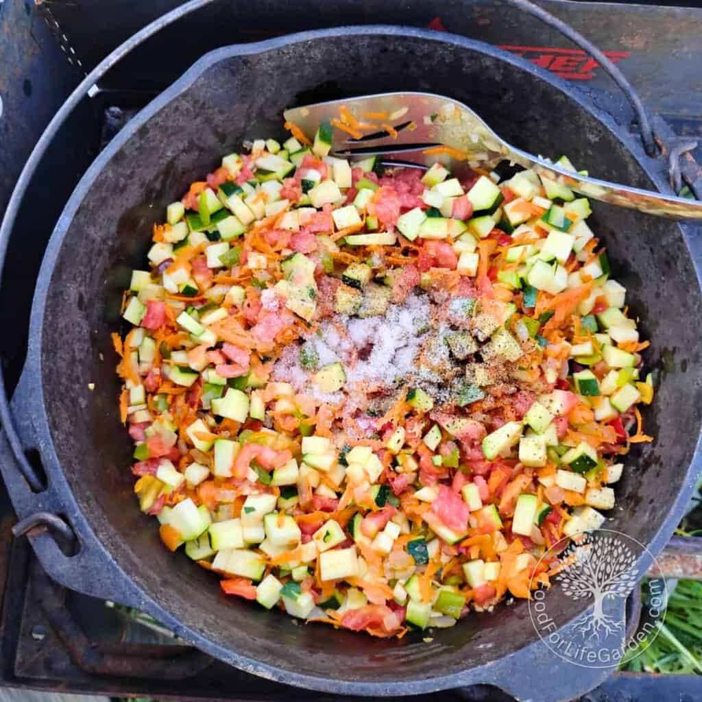 Seasonings are added to zucchini ikra ingredients in a dutch oven.
