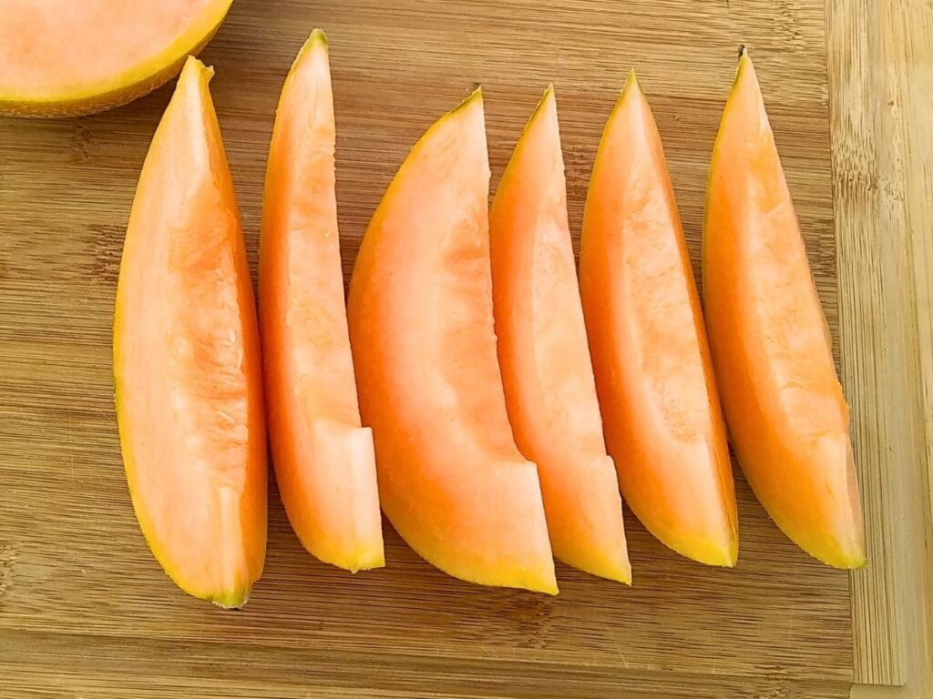 slices of cantaloupe on a cutting board. 
