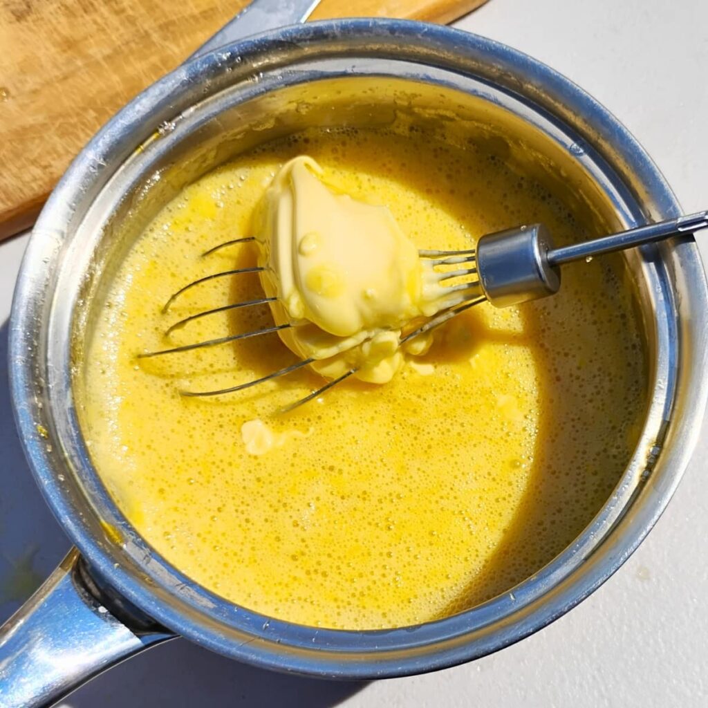 butter is added to a pot with lemon curd ingredients to get mixed in