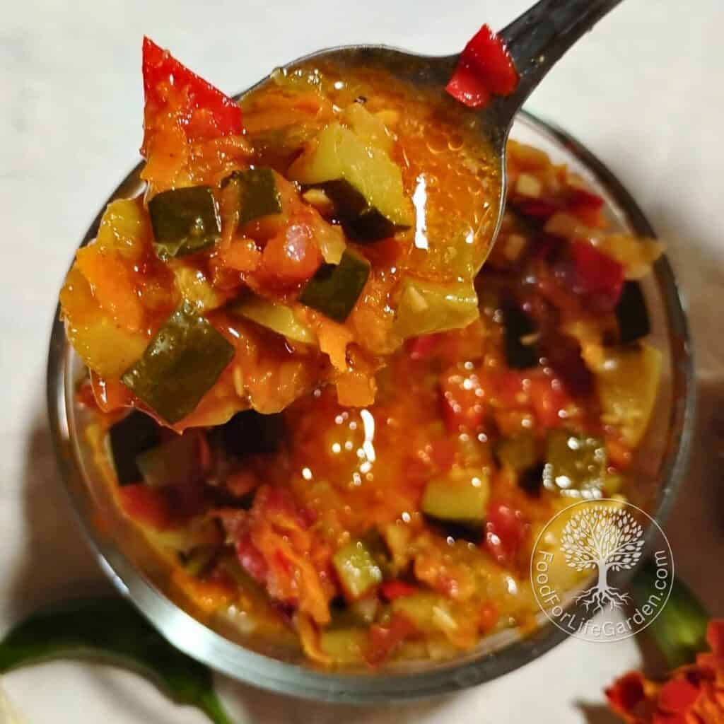 bowl filled with zucchini ikra and a spoon removing some, lifted up from the bowl.