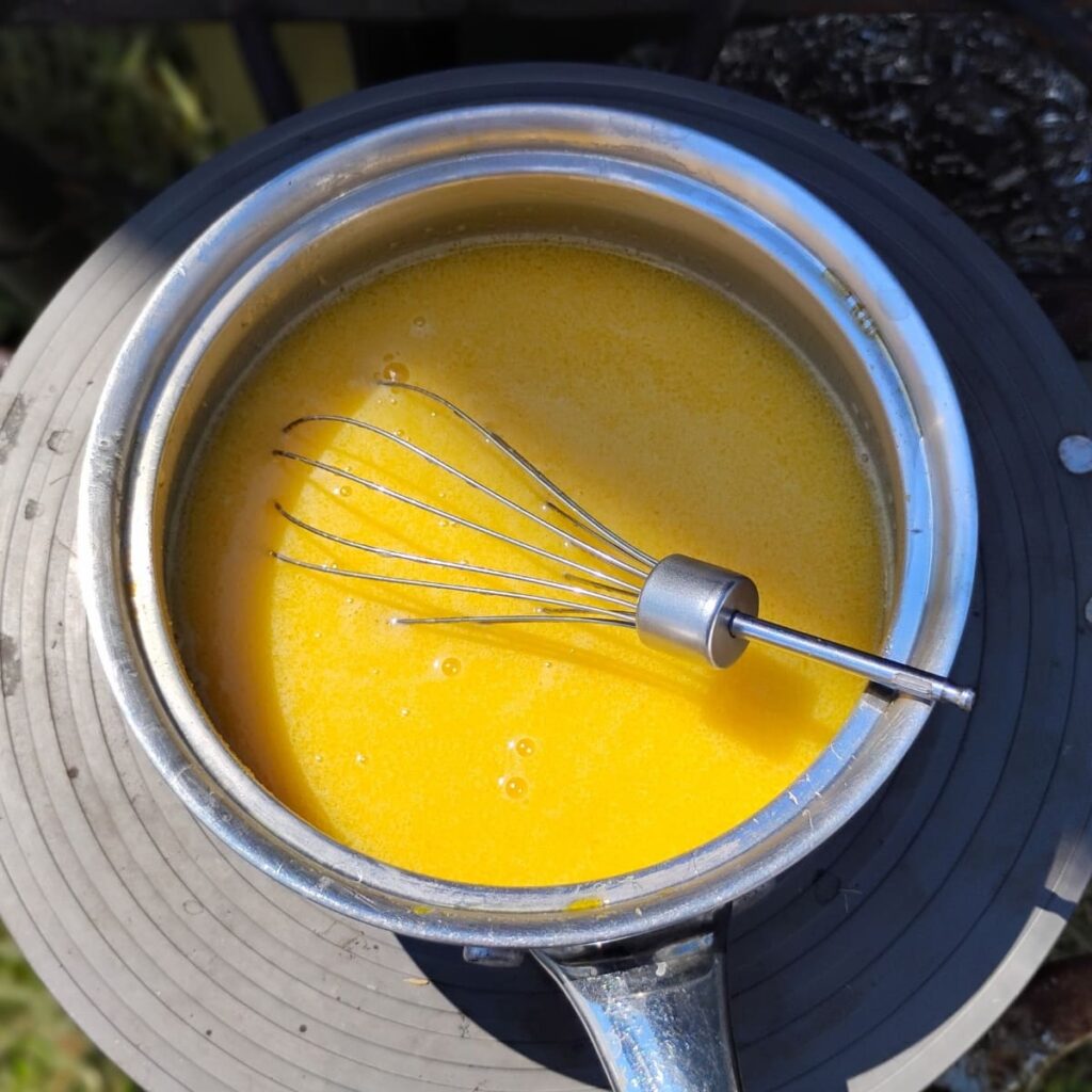 lemon curd getting heated on a burner.