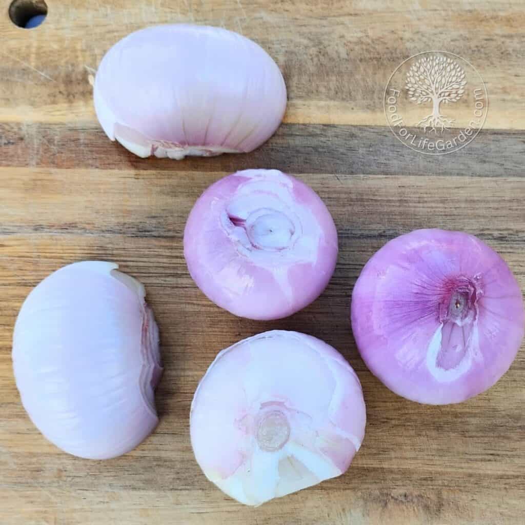 four smaller onions on a cutting board ready to get chopped up for making ikra.