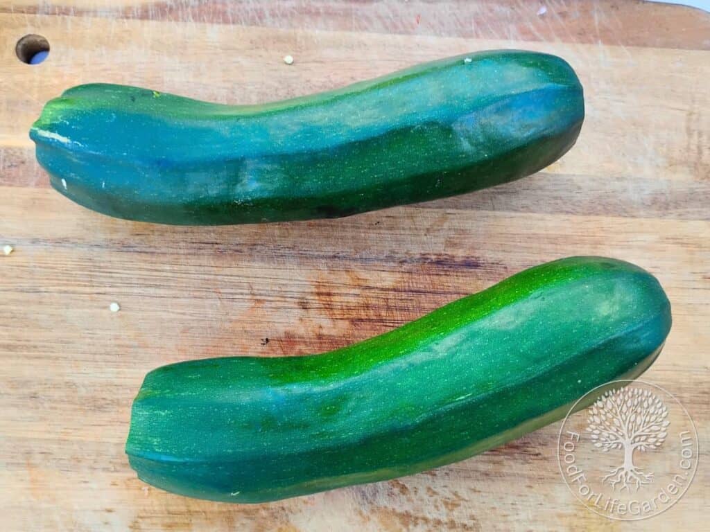 two large zucchini on a cutting board.