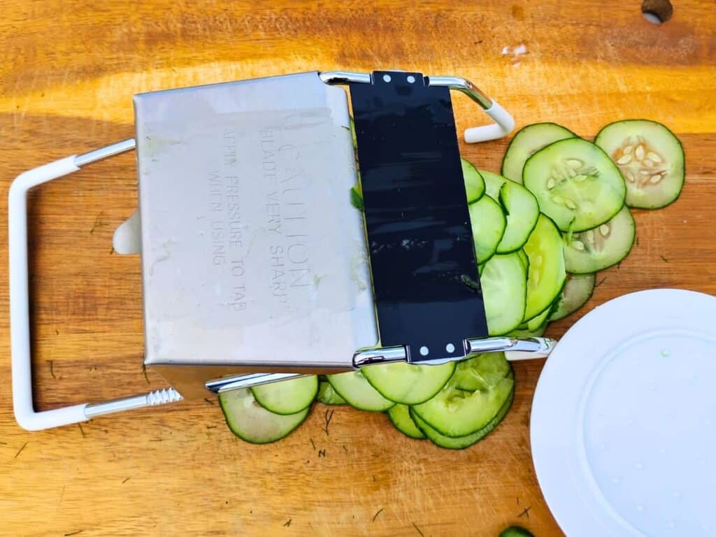 A mandolin is used for slicing the cucumbers paper thin.