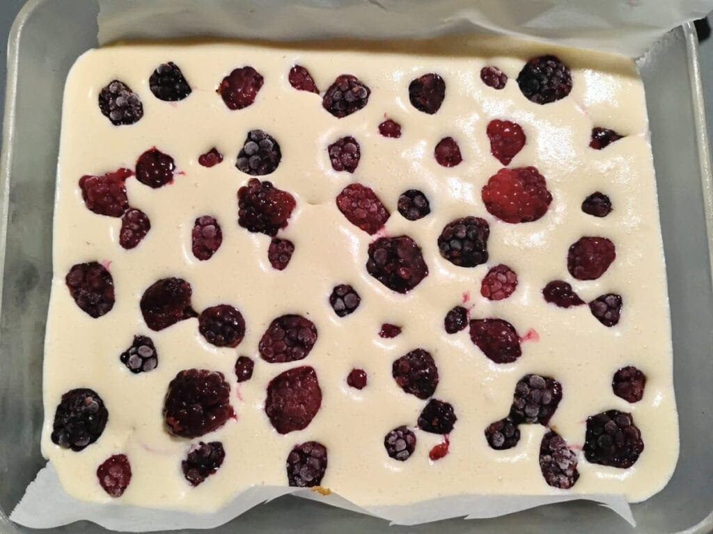 blackberries were added to the cheesecake base in the baking dish.