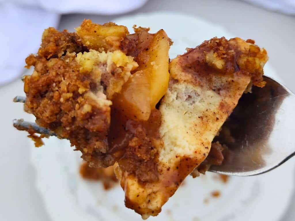 photo shows a fork with a chunk of apple pie cheesecake lifted up.