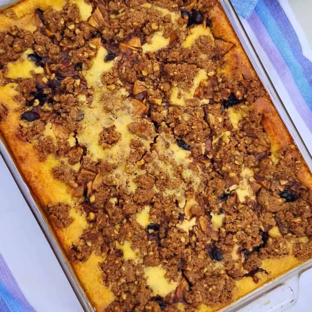 Finished baking, a apple crisp cheesecake with cranberries and walnuts.