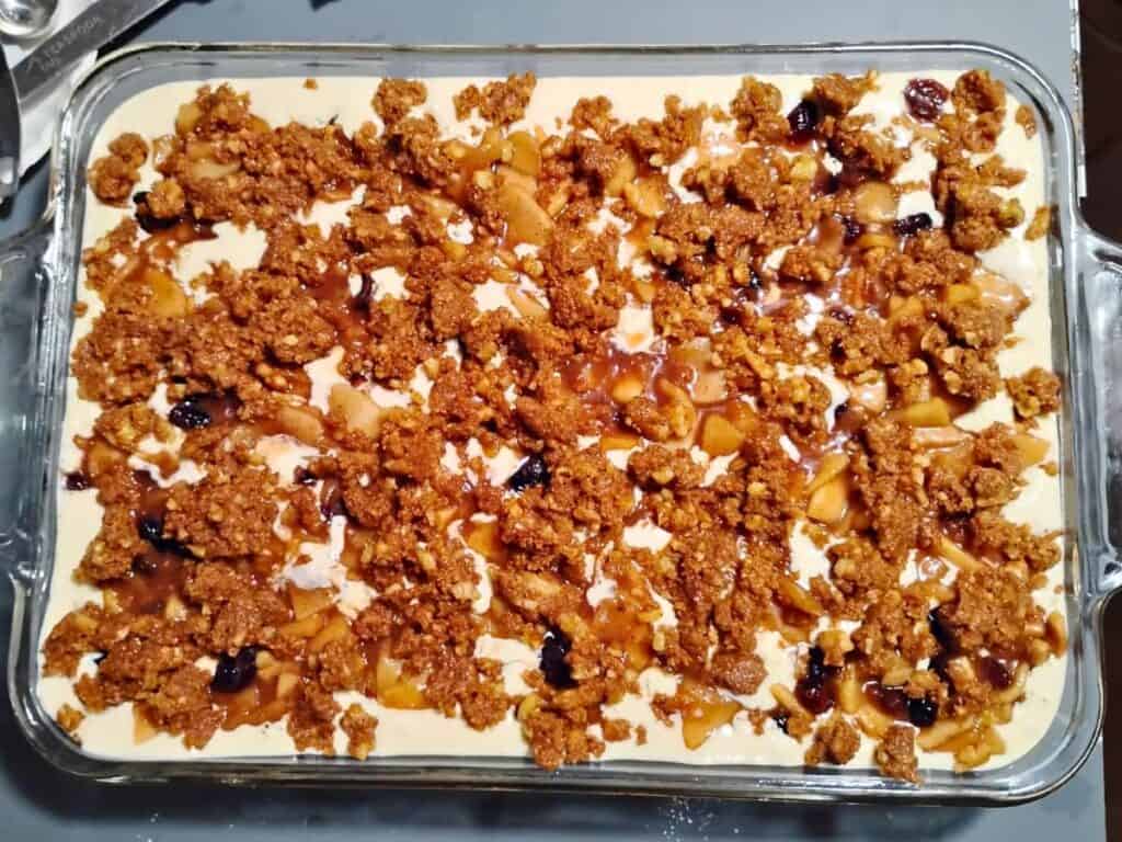 baking dish with all layers of apple pie cheesecake assembled