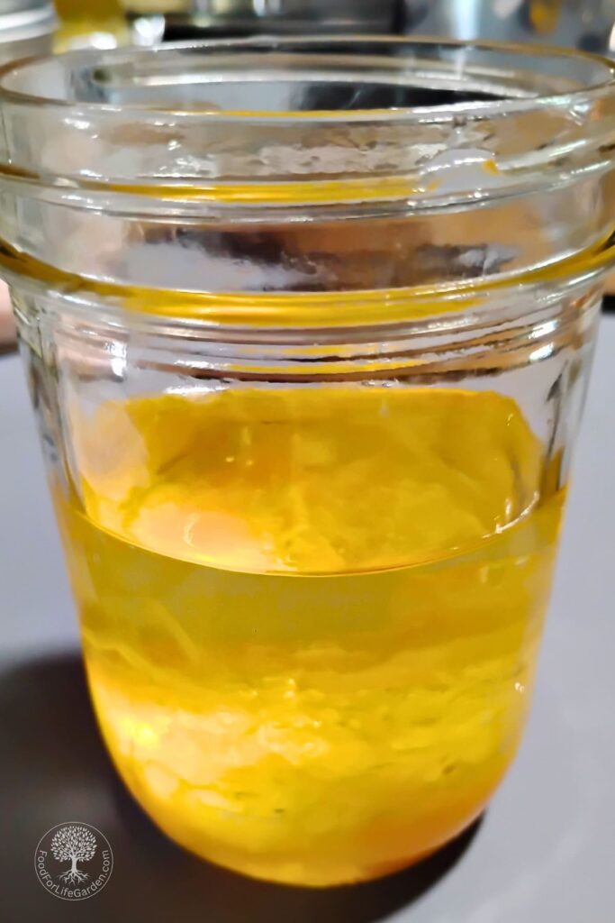 Jar filled with homemade mayonnaise ingredients.