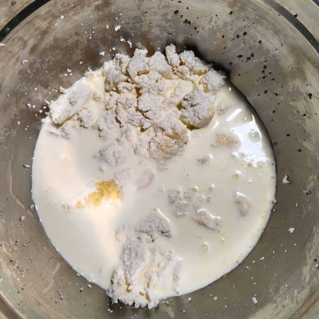 cream is added to a bowl with queso fresco cheese.