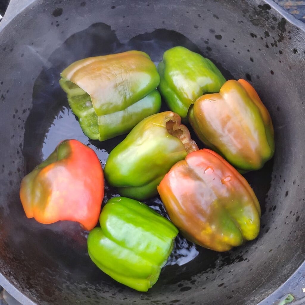 Bell peppers getting fried in a Dutch oven.