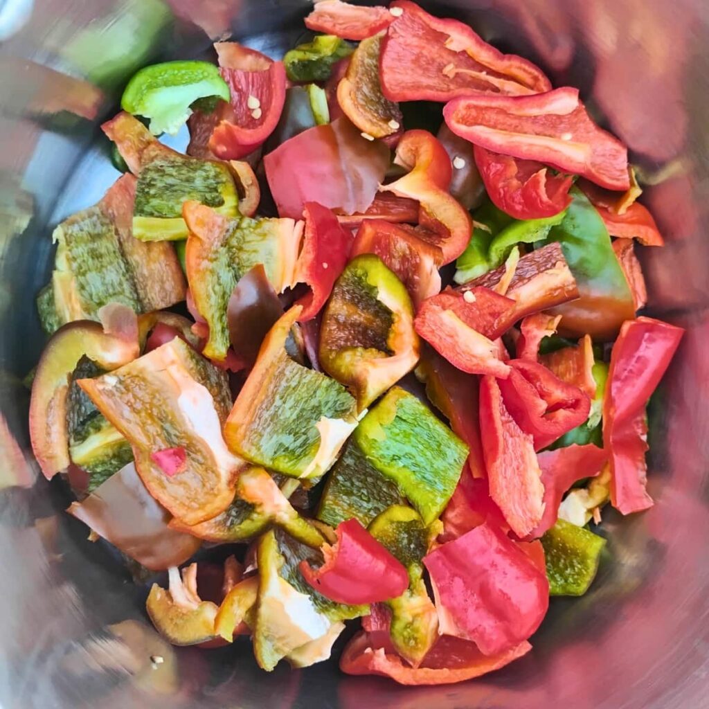 red and green chopped peppers in a pot