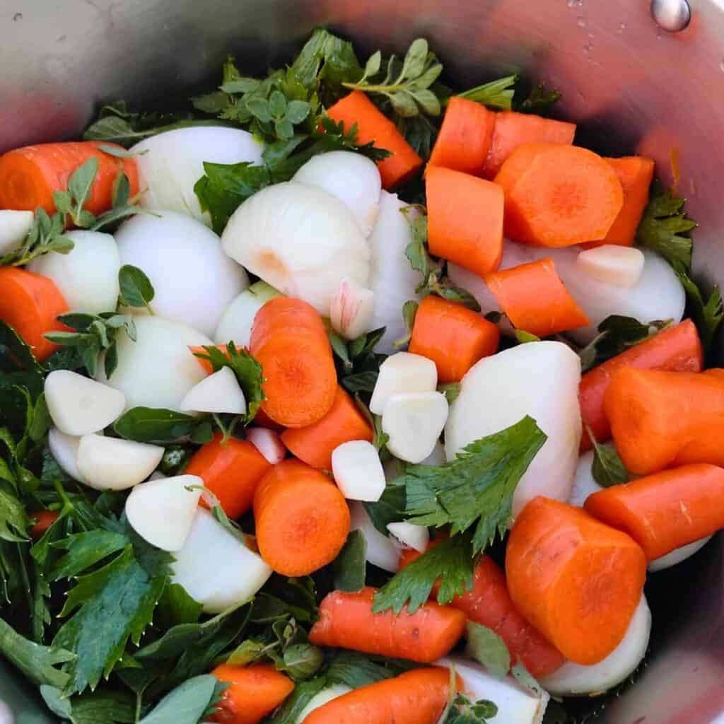 chopped carrots, onions, peppers, garlic, and celery in a pot for making sauce.