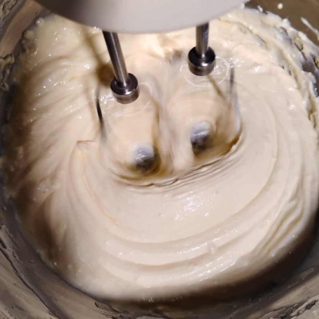 photo of a mixer beating a cheese batter for cake filling.