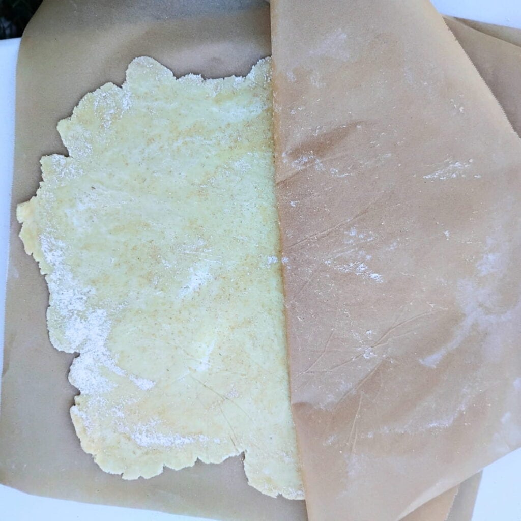 rolled out pie crust between two sheets of parchment paper.