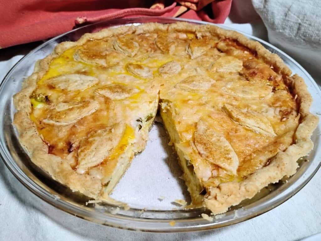Fresh baked jalapeno pie on a pie plate with a slice missing. 