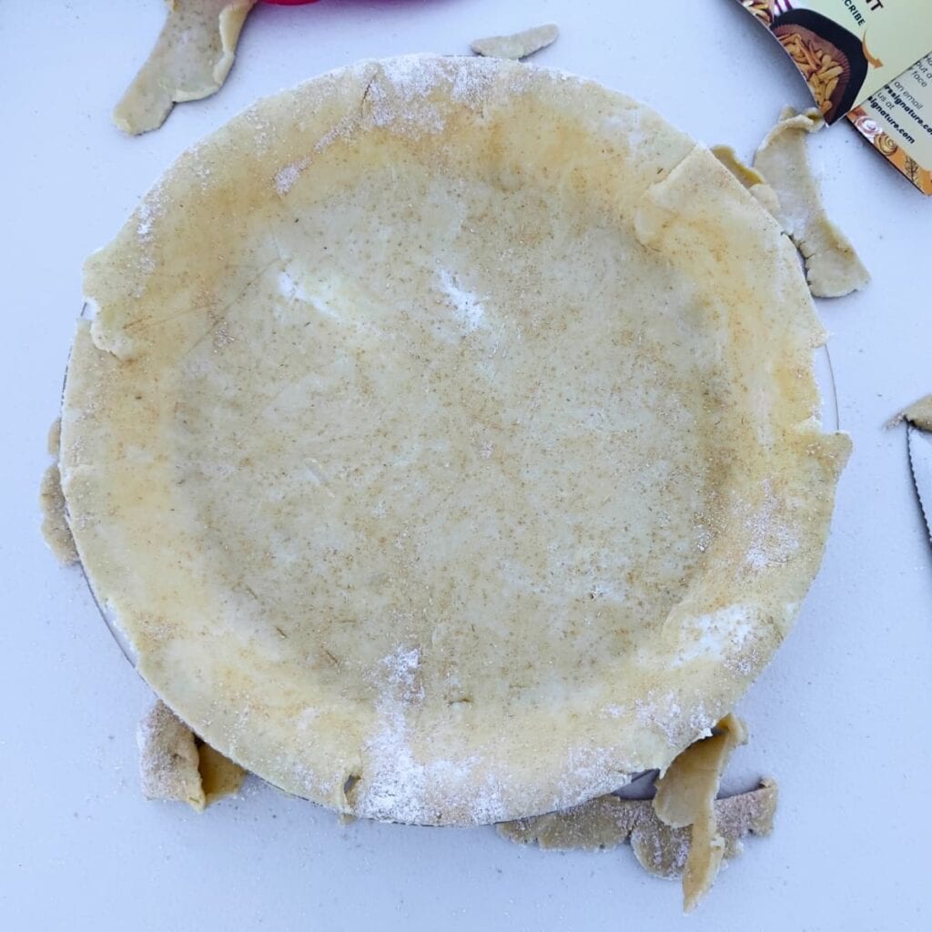 pastry has been added to a  dish and the edges got trimmed. 